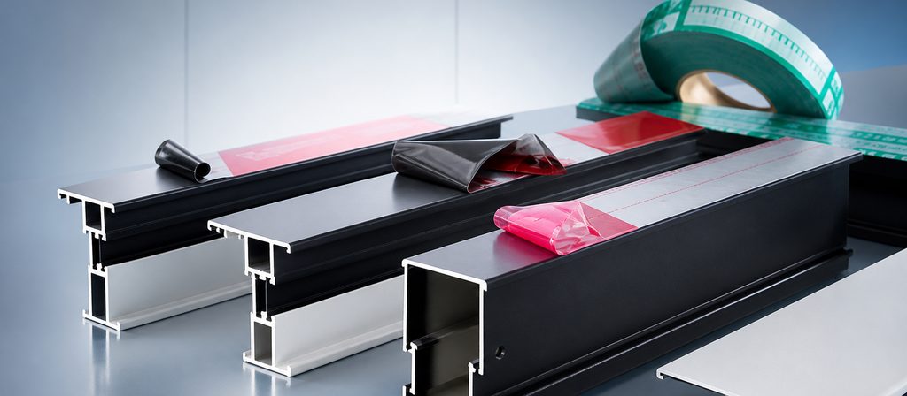 Perfiles de aluminio negro y blanco con películas protectoras de distintos colores aplicadas sobre las caras vistas